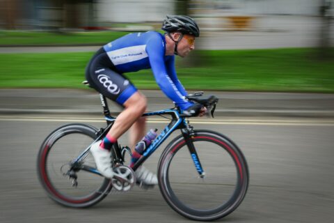 cyclist races by with bare legs