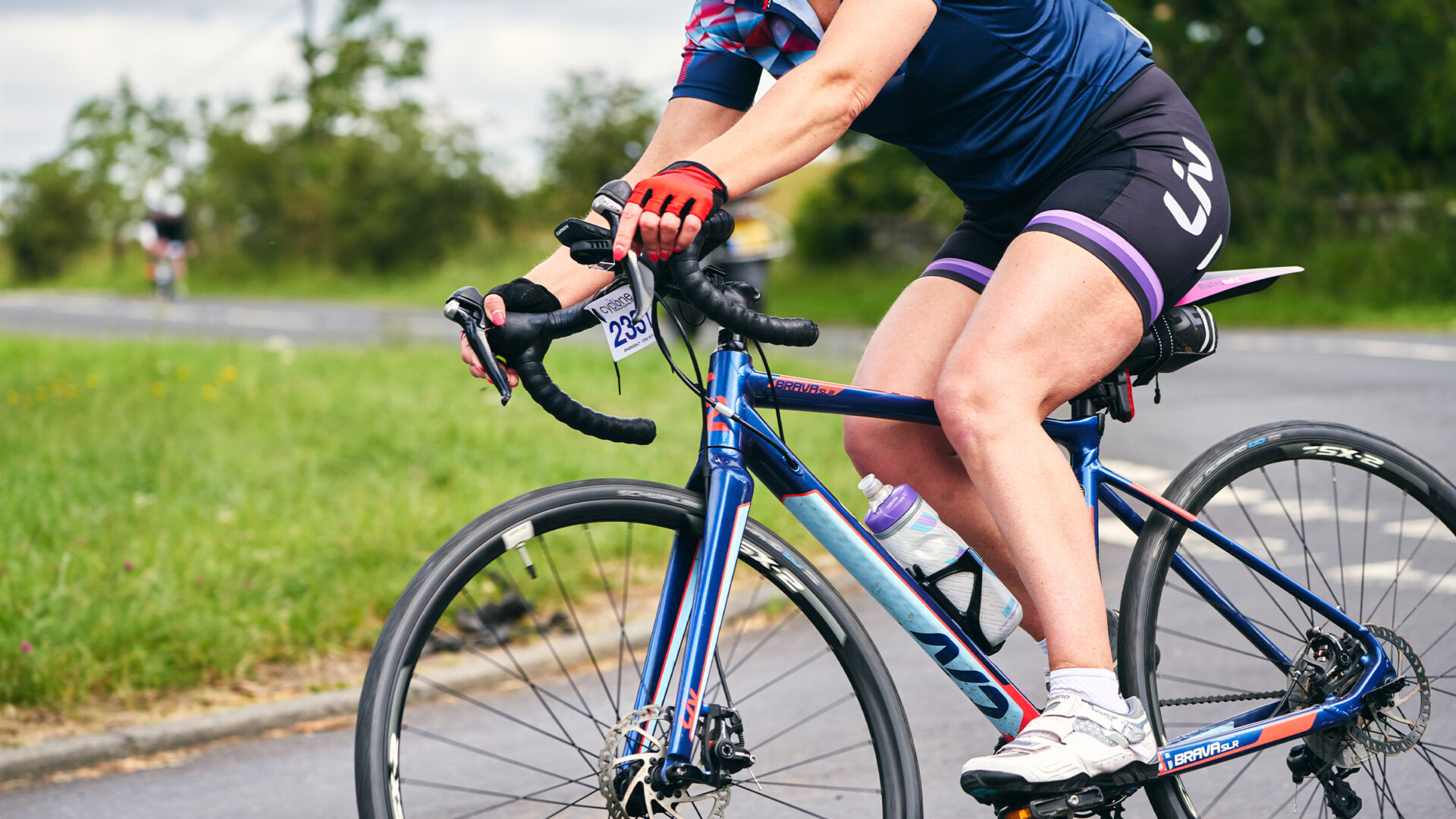 Torso of a woman rounding a steep switchback on her bike.