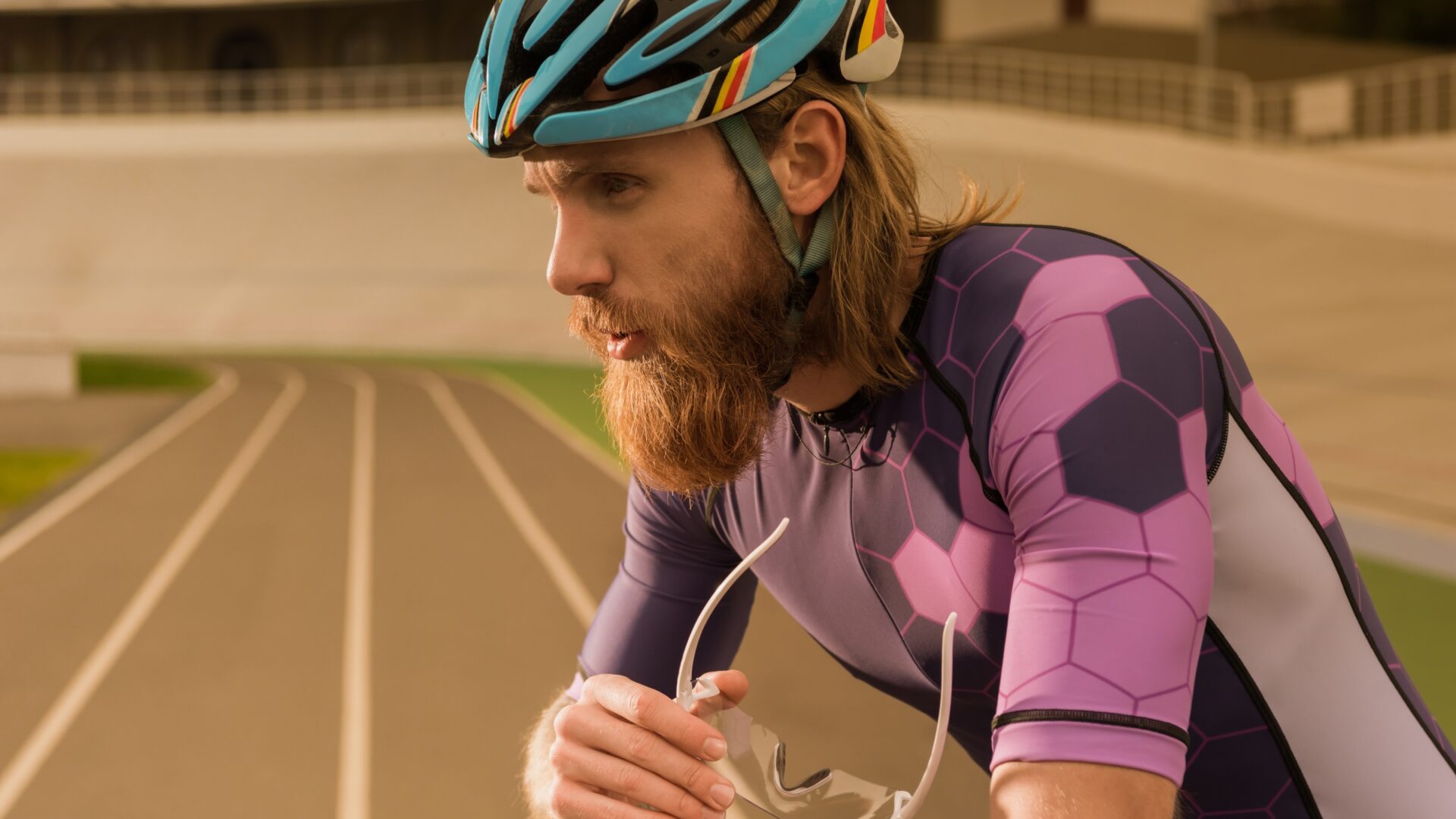 Bearded cyclist resting inside a velodrome