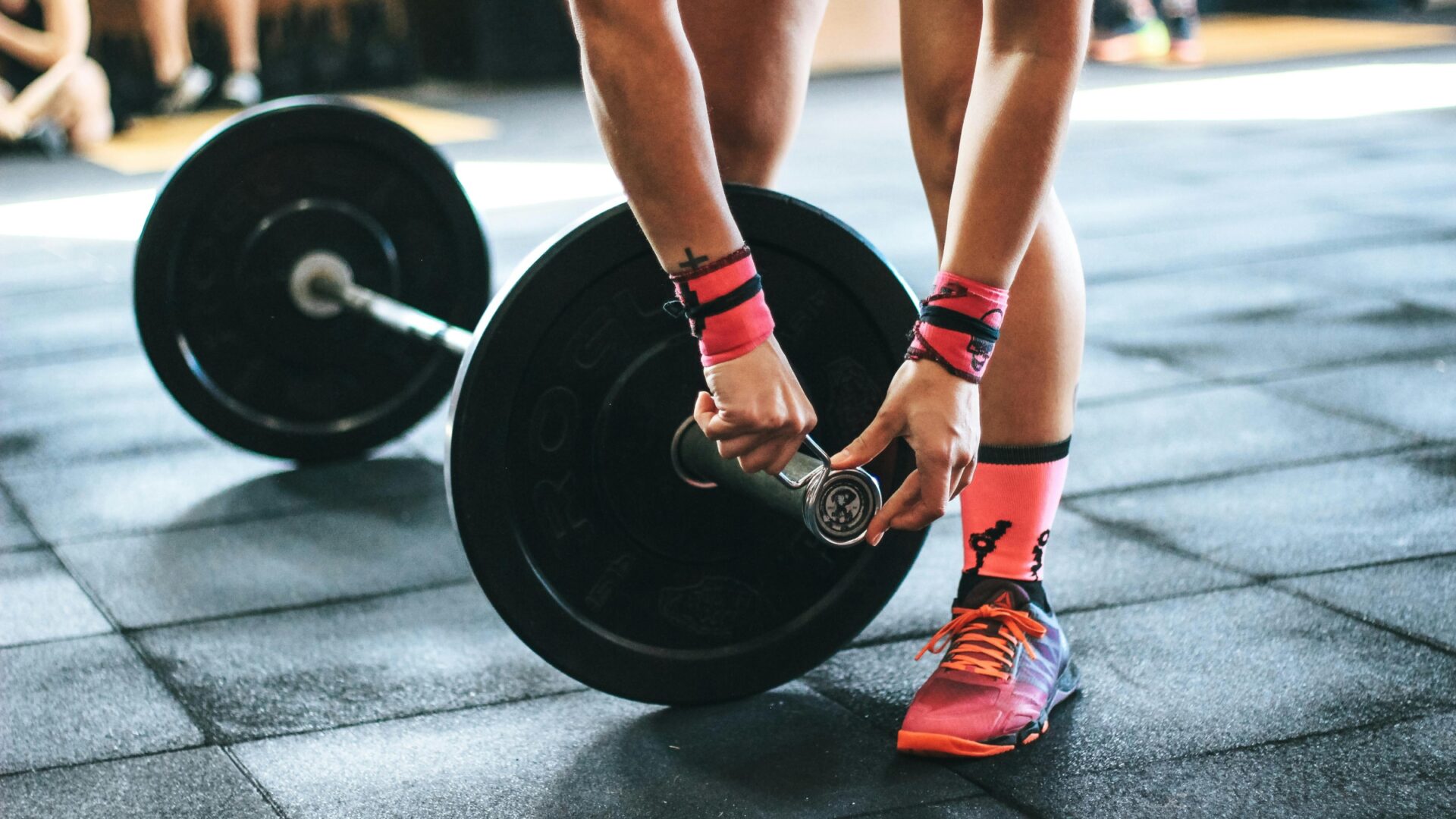 Athlete putting a collar on a weighted barbell