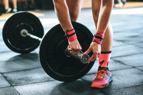 Athlete putting a collar on a weighted barbell