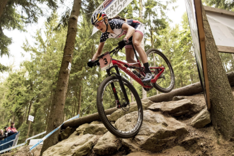 Kate Courtney mountain biking down a hill