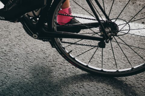 Close up shot of cycling shoes on the bike shot through the back tire