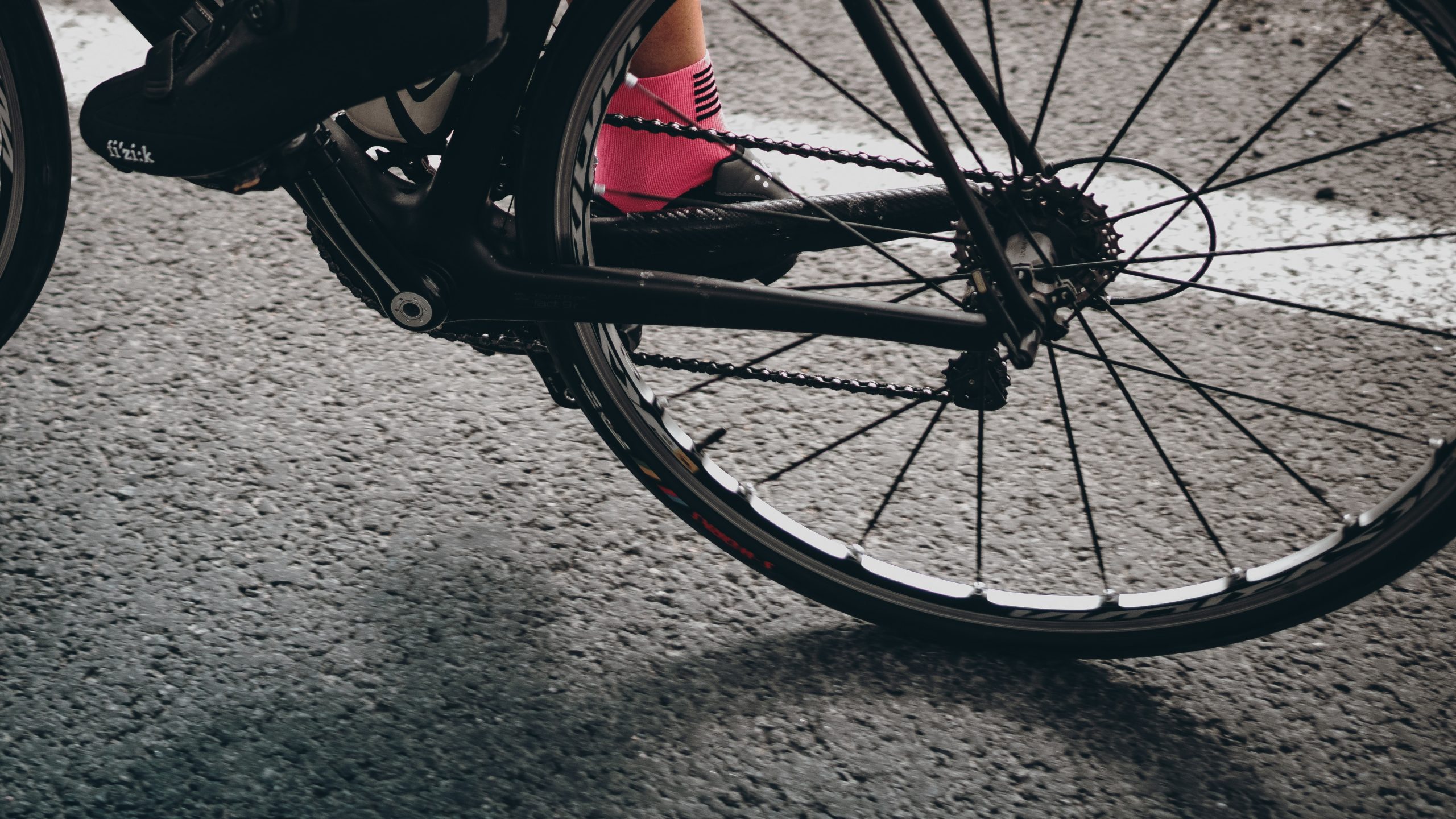 Close up shot of cycling shoes on the bike shot through the back tire
