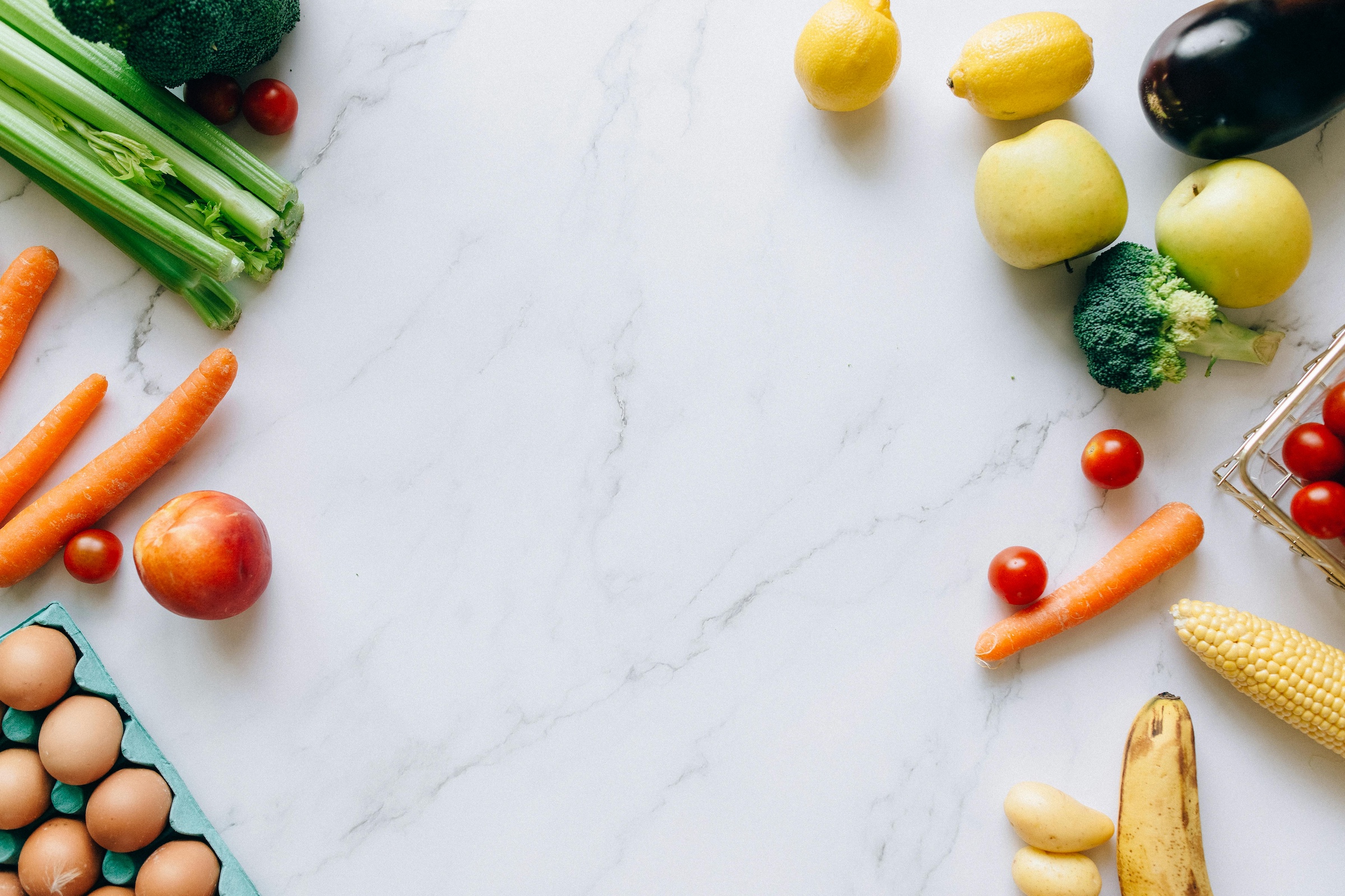 Assorted fruits and vegetables on marble table for sports nutrition