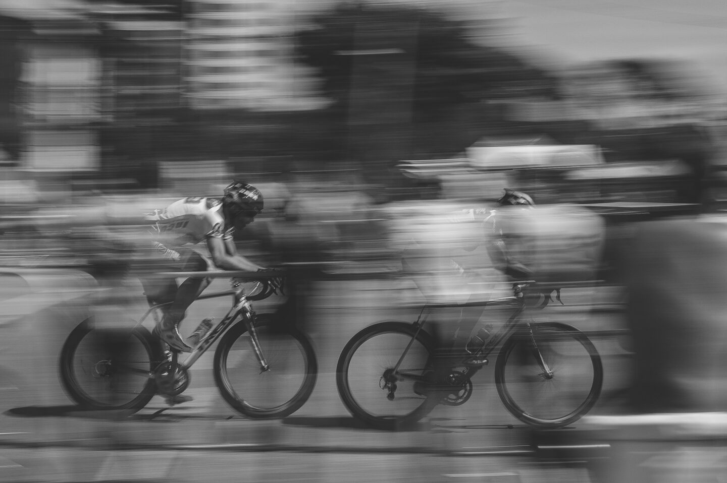 two cyclists streak past