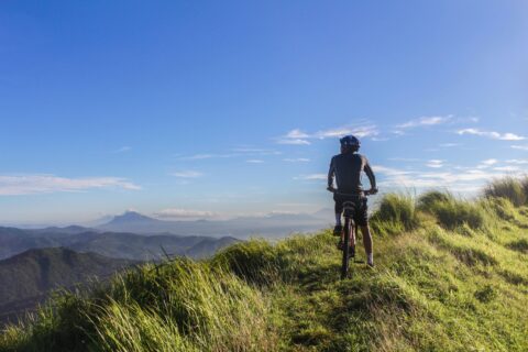 Cyclist on top of mountain view for false cycling beliefs