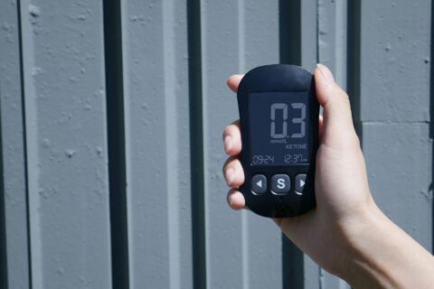 hand holding a blood tracker to monitor ketones