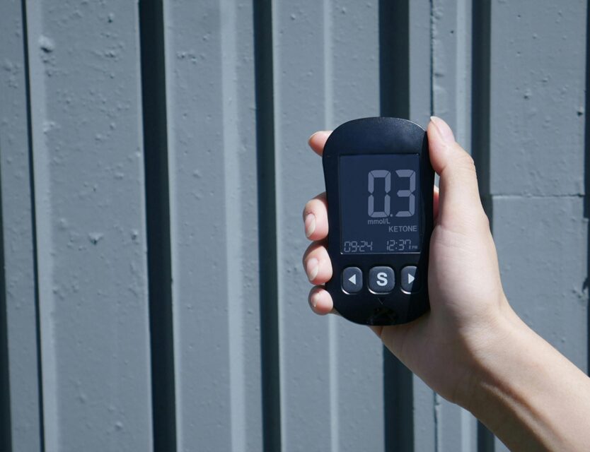 hand holding a blood tracker to monitor ketones