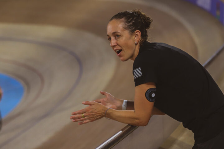 cycling coach encourages a racer at a track cycling race