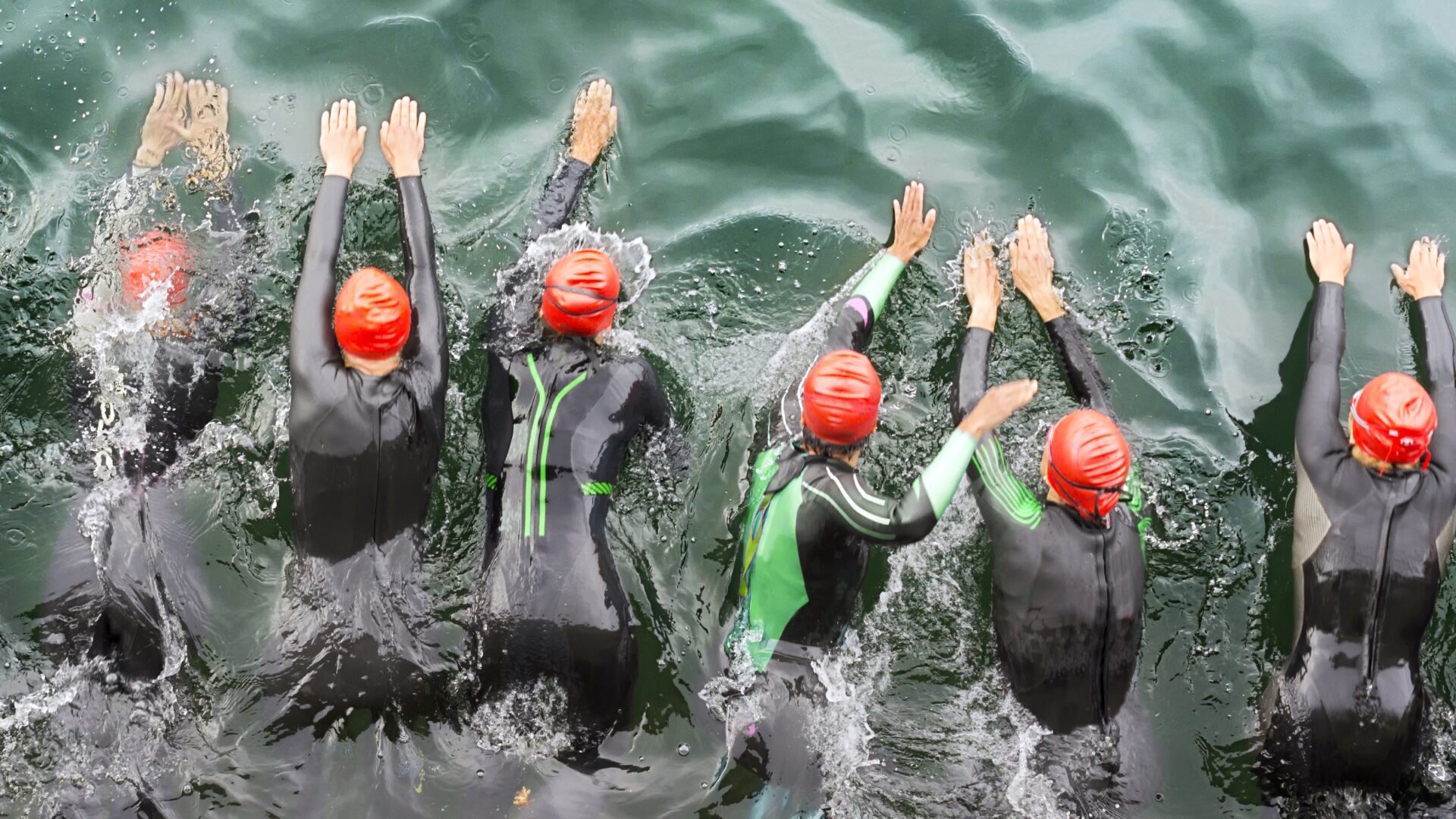 Triathletes starting their open-water swim portion of a race