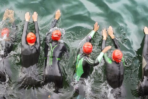 Triathletes starting their open-water swim portion of a race