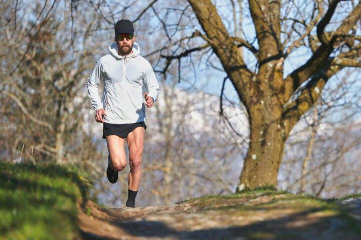 Young man running athlete during a workout in a hill