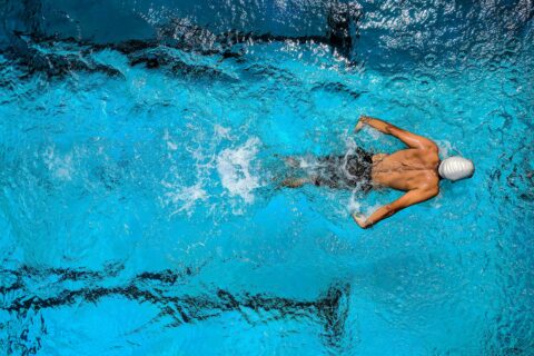 man swimming in a pool aerial view