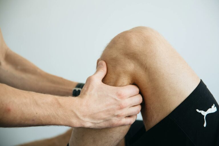 Athlete and trainer stretching knee