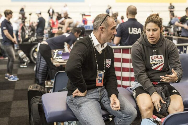 USA Cycling coach talks with a female cyclist athlete during a race