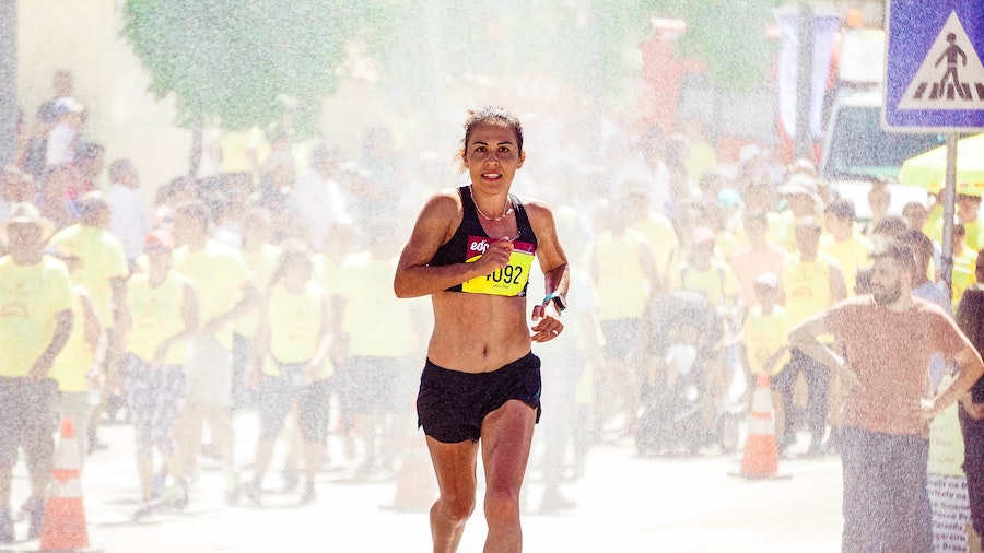 a woman runs through mist in running race