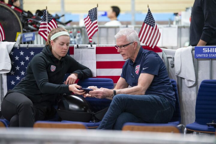 USA Cycling coach shares data with a female athlete at a race