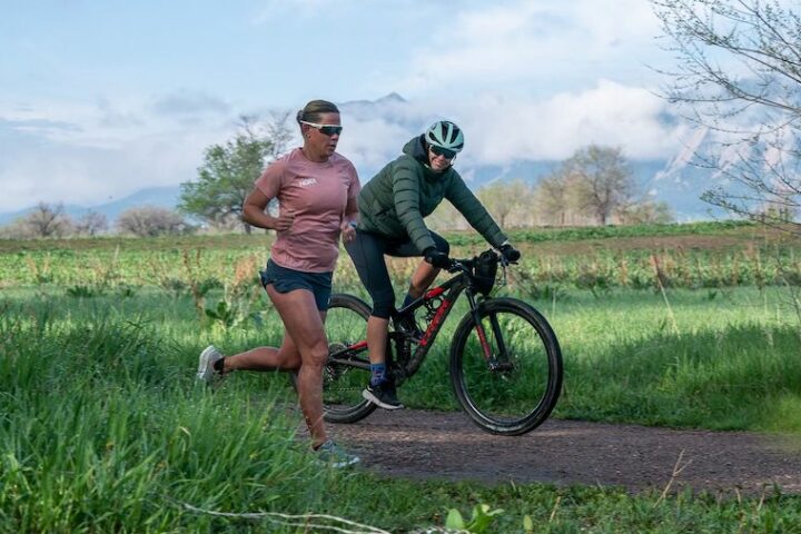 Coach Julie Dibens rides alongside one of her athletes, three-time Ironman world champion Mirinda Carfrae.