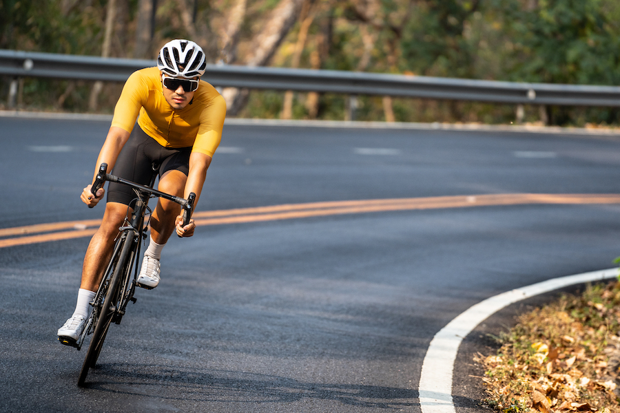 Man in yellow cycling jersey riding a road bike during a VO2max workout.