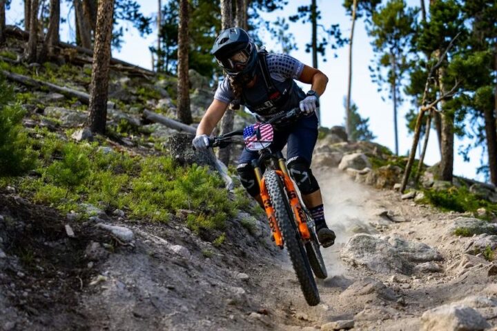 Julie Young riding her mountain bike down a rocky trail