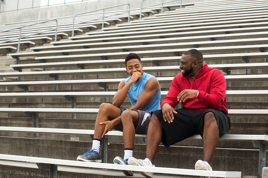 Coach and athlete talking on bleachers