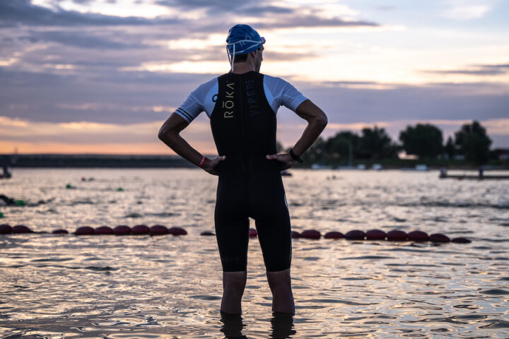 triathlete looking out at the water at sunrise