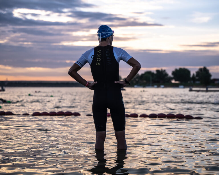 triathlete looking out at the water at sunrise