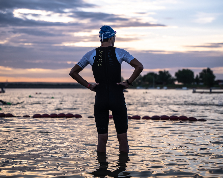 triathlete looking out at the water at sunrise
