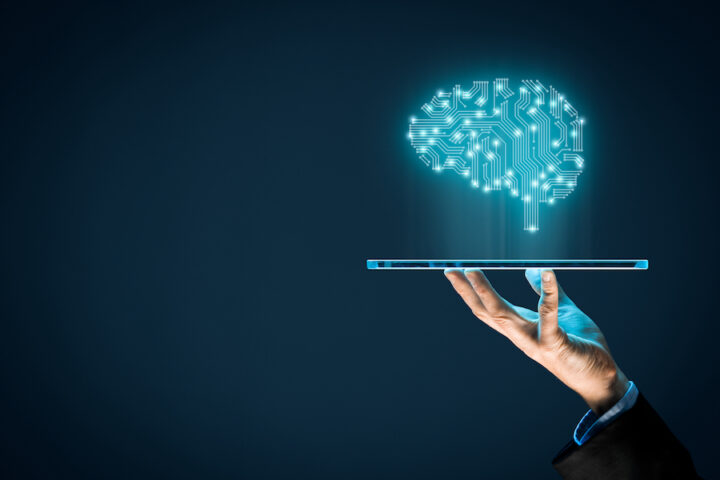 Artificial intelligence (AI), machine deep learning, data mining and another modern computer technologies concepts. Brain representing artificial intelligence and businessman holding futuristic tablet