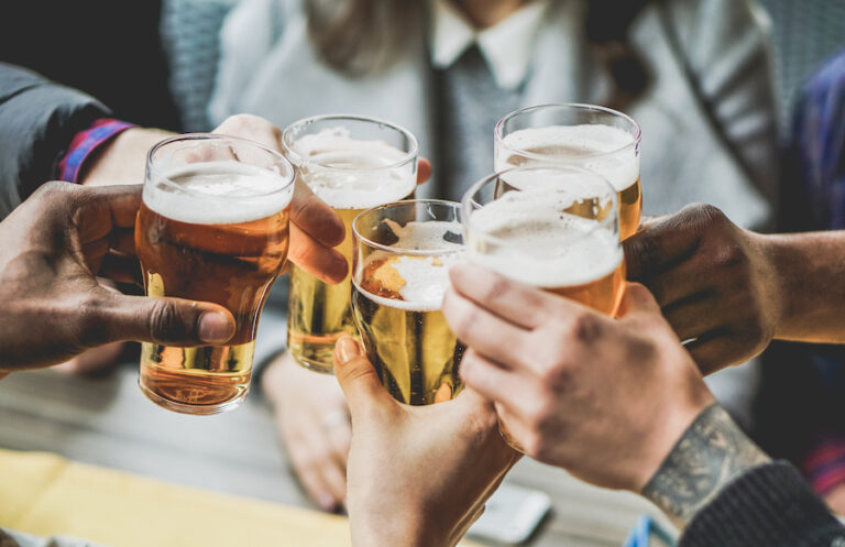 a group celebrates with beers