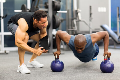 athlete being coached in gym by trainer