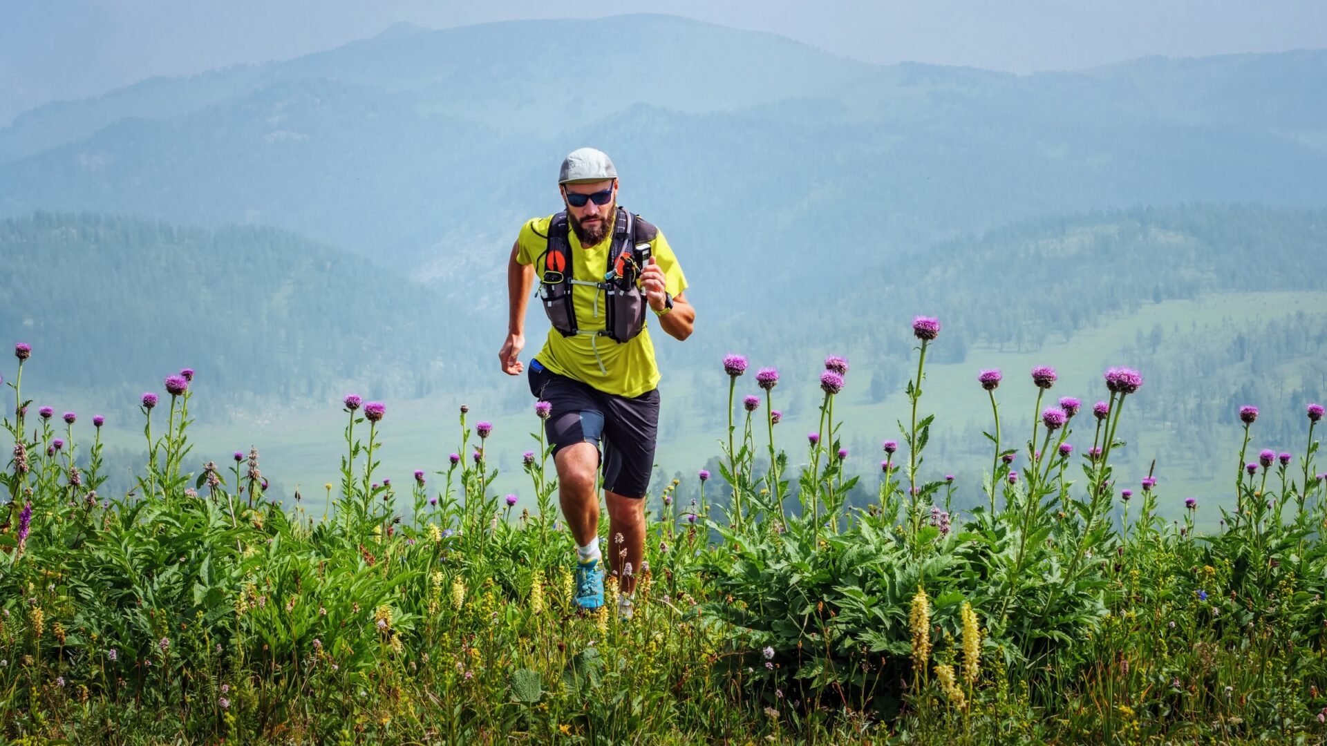 Ultra runner cresting a hill with flowers