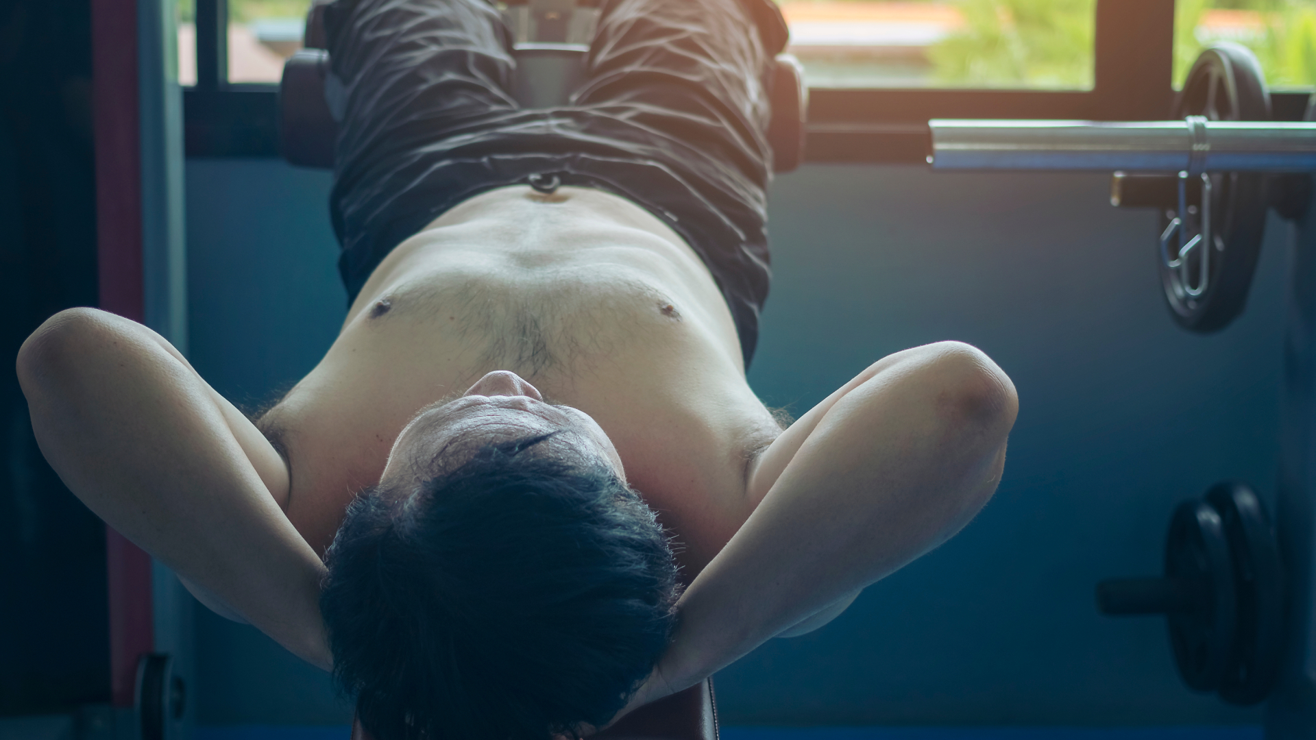 Shirtless middle-aged man doing decline sit-ups