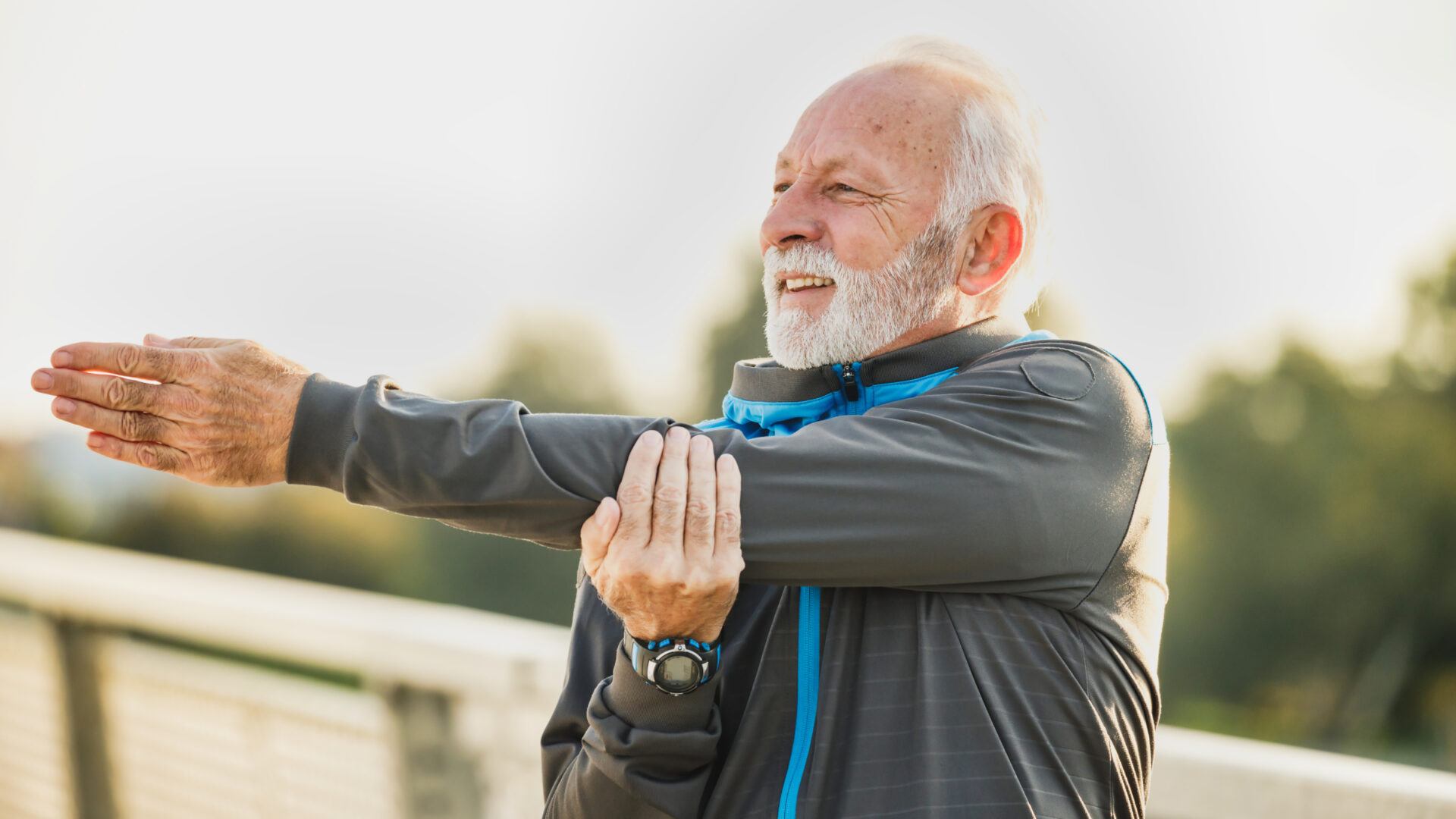 Masters runner performing an arm stretch before a run