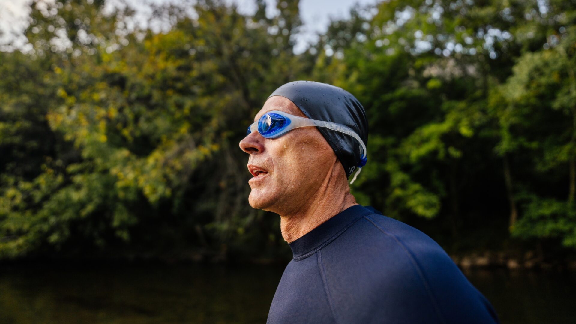 A senior triathlete coming out of swimming in the river, as part of triathlon training.