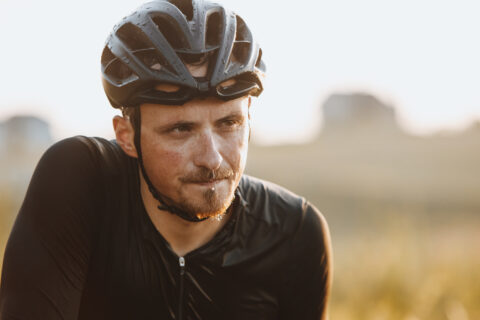 A cyclist pauses in the discomfort of a hot ride to drench himself in water