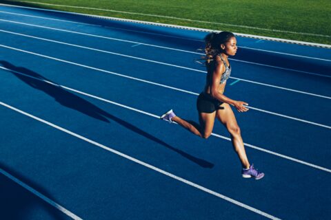 Woman running intervals on a blue outdoor running track