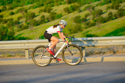 Female cyclist working on in-saddle horsepower while climbing a slight grade