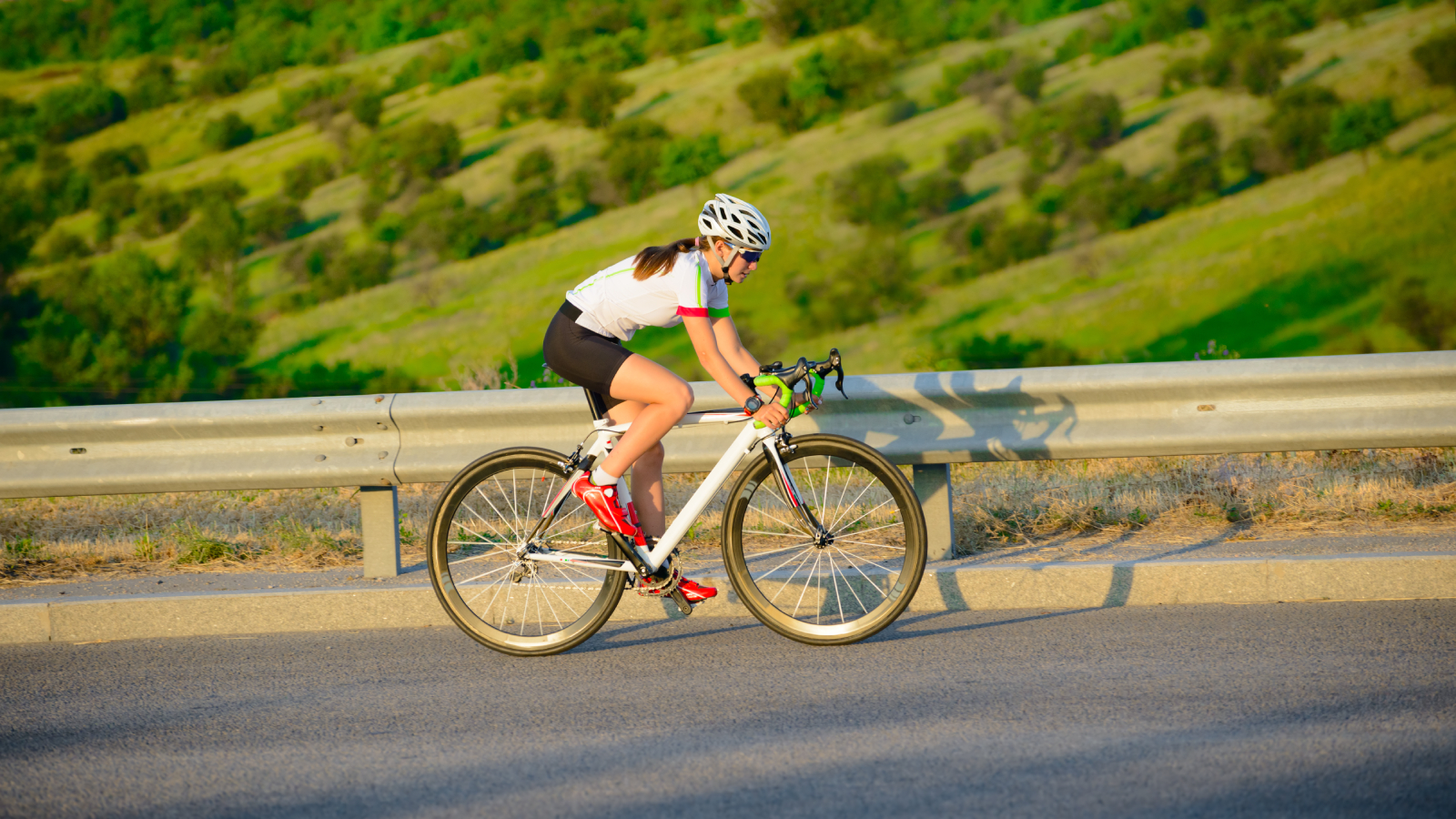 Female cyclist working on in-saddle horsepower while climbing a slight grade