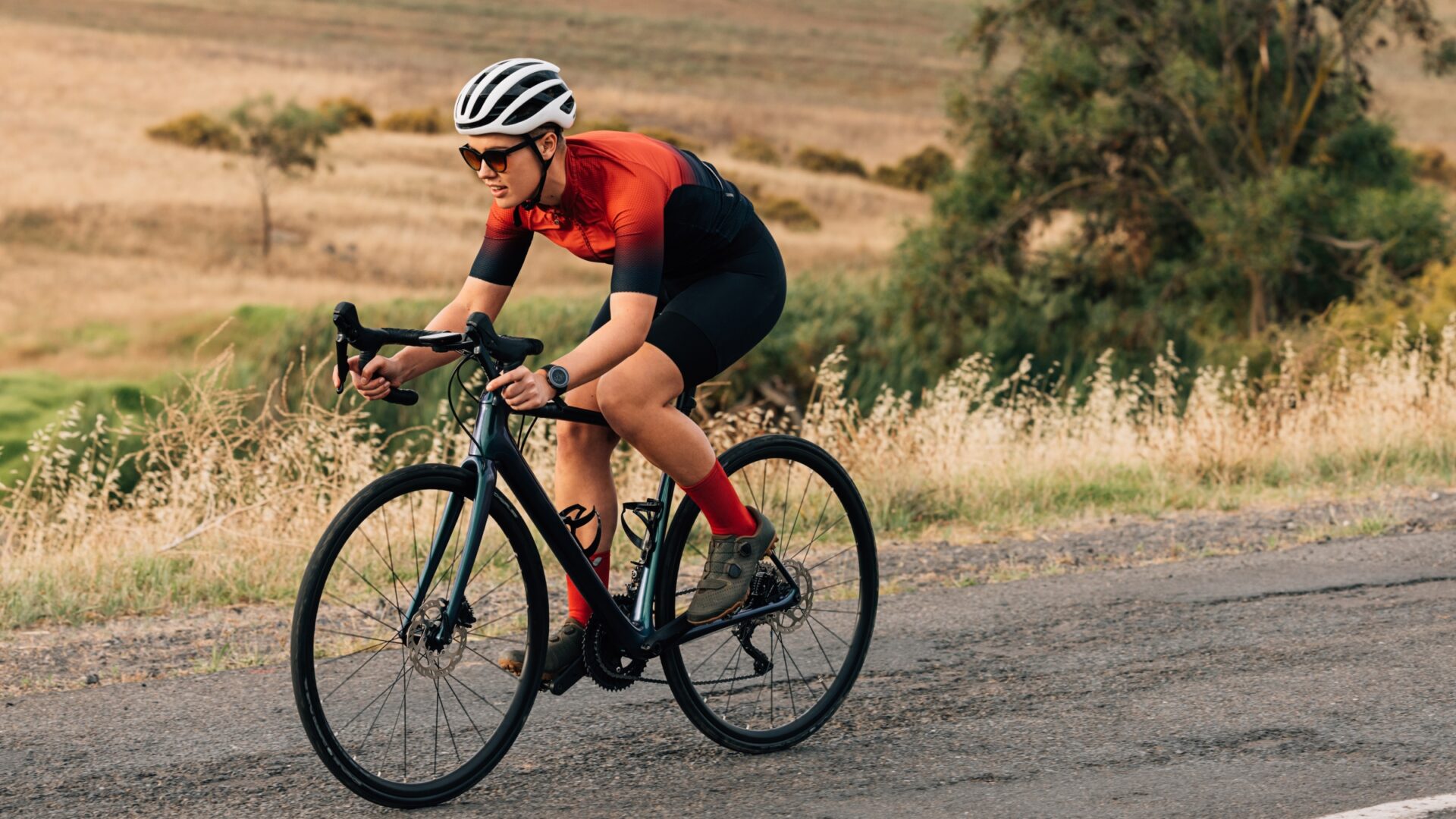 Woman cycling through grassy hills