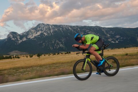 A triathlete on his bike, doing interval training along a country road