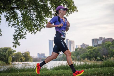 Professional triathlete Skye Moench runs in a purple triathlon suite during a triathlon race.