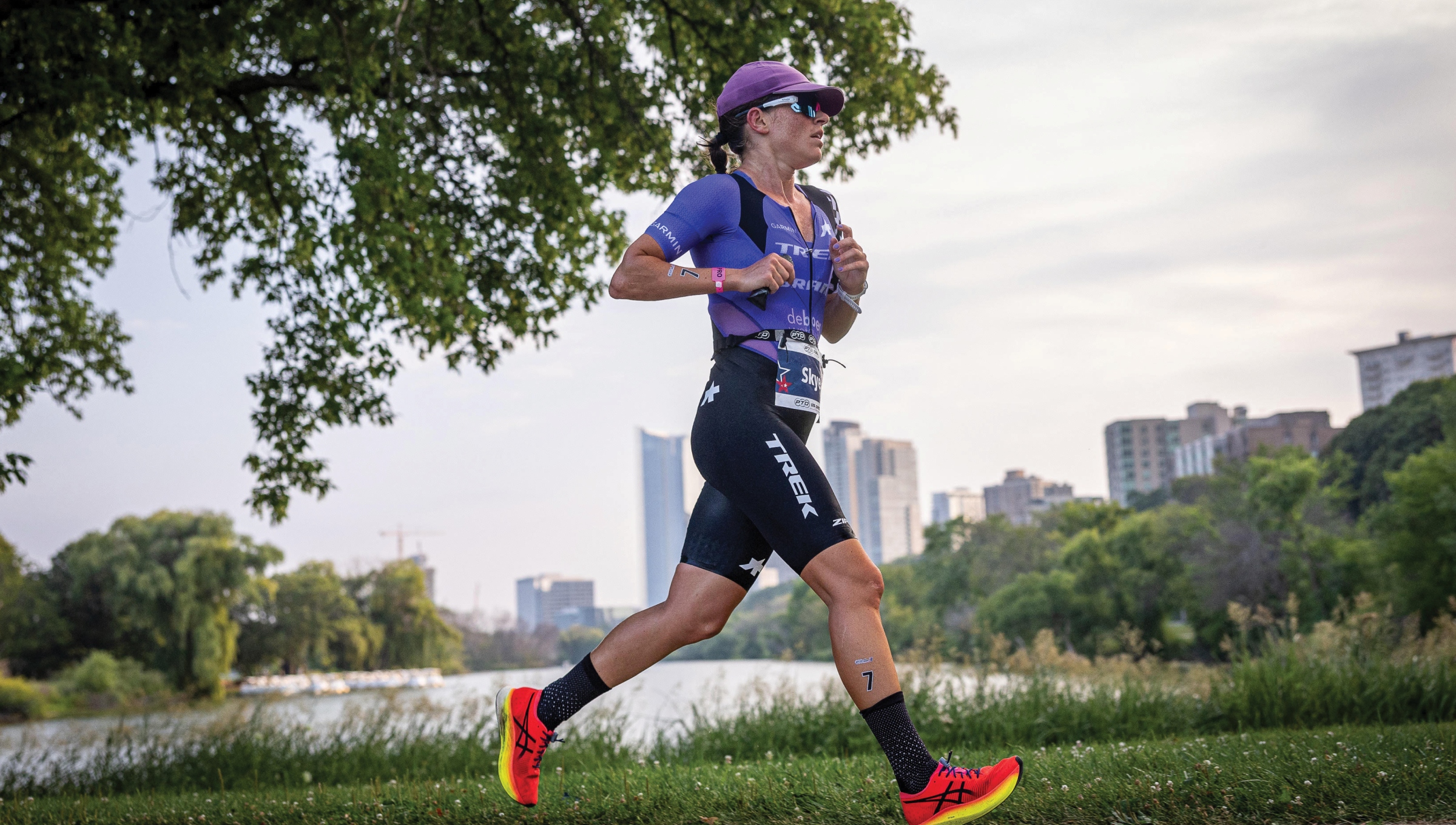Professional triathlete Skye Moench runs in a purple triathlon suite during a triathlon race.
