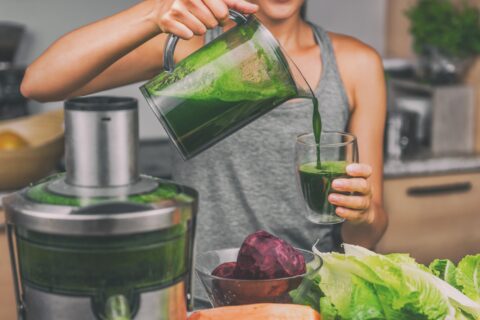 Woman pours freshly-squeezed juice into a glass