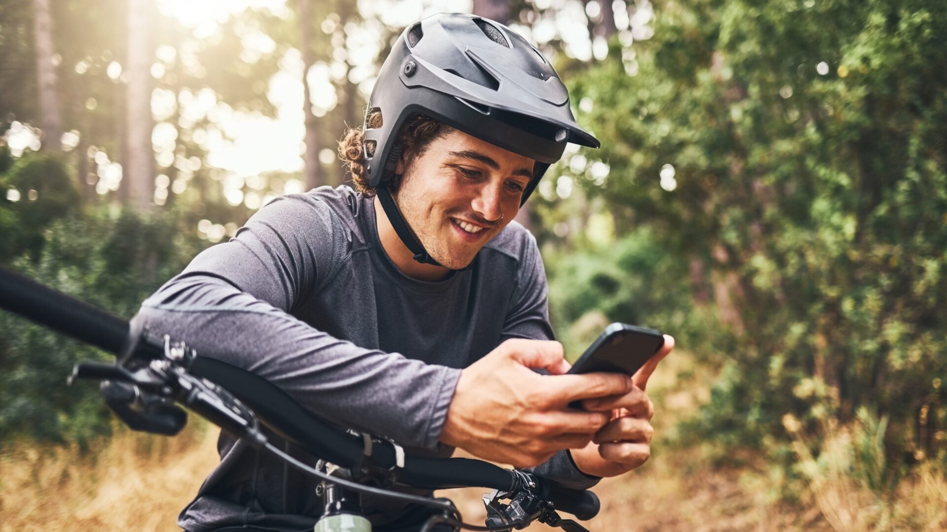 Mountain biker smiling at his phone.