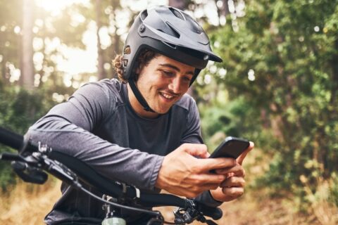 Mountain biker smiling at his phone.