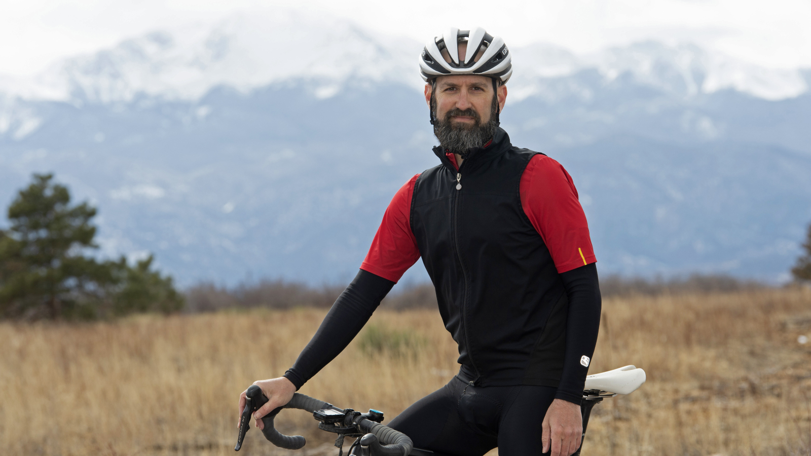 Jim Rutberg standing in front of Pikes Peak with his bike.