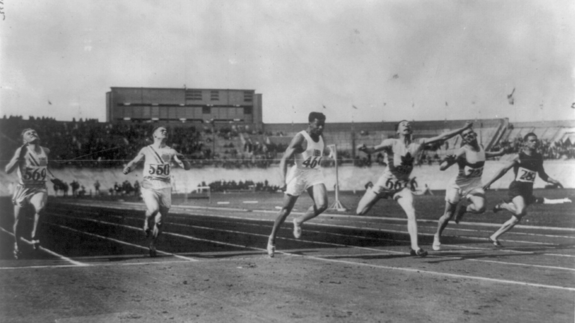 Black and white image of runners straining to cross the finish line.