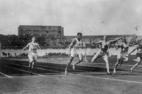 Black and white image of runners straining to cross the finish line.